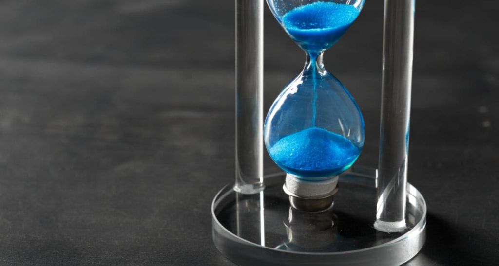 Time is passing Blue hourglass close up