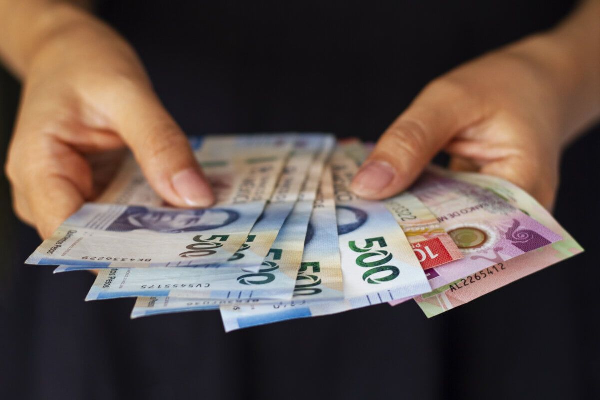 high angle hands holding mexican banknotes