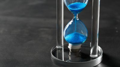 Time is passing Blue hourglass close up